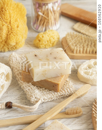 Beige handmade soap bar on soap saver bag near hygiene Items close up 108562910