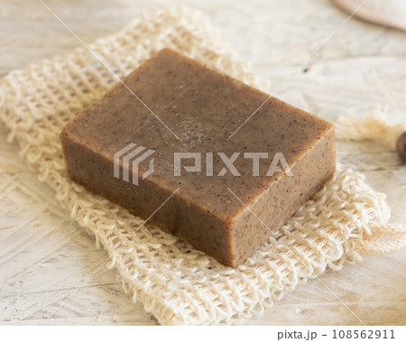 Brown handmade soap bar on soap saver bag  close up. Organic skincare products 108562911