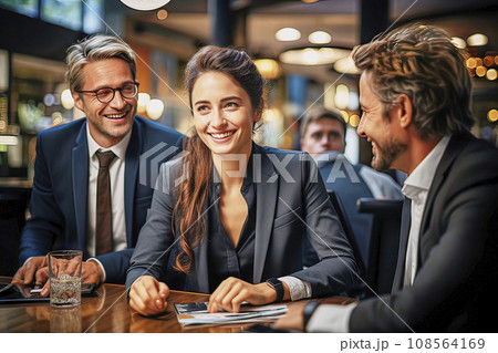 Smiling Young Businesswoman in Dark Suit Among Older Men at a Table Smiling Young Businesswoman in Dark Suit Among Older Men at a Table 108564169