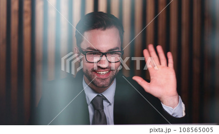 Young handsome businessman goodbye to the client and waves his hand. Young handsome businessman goodbye to the client and waves his hand. 108565005