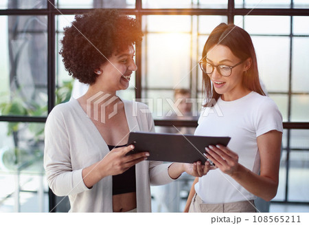 Two women analyzing documents office. Woman executives at work in office discussing some paperwork. 108565211