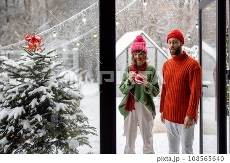 Young couple decorates Christmas tree at backyard 108565640