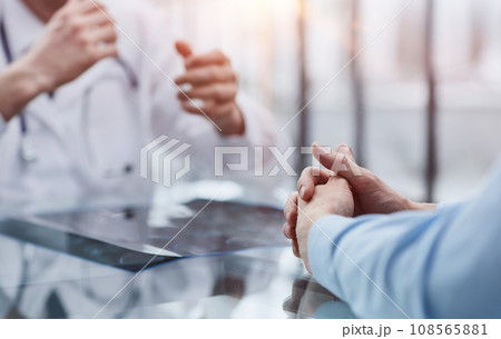 the doctor and the patient at the reception are discussing the x-ray the doctor and the patient at the reception are discussing the x-ray 108565881