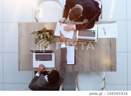 Two successful smiling businessmen are working on a laptop. view from above 108565916