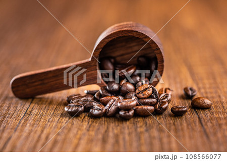 Roasted coffee beans in wooden scoop on wooden table. Roasted coffee beans in wooden scoop on wooden table. 108566077