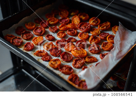 Trays of fresh cherry tomatoes on racks drying in the oven Trays of fresh cherry tomatoes on racks drying in the oven 108566541