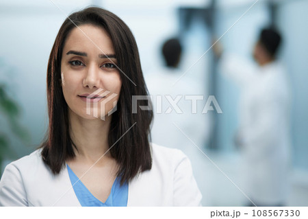 Image of confident female doctor, intern with medical robe, looking confident at camera 108567330