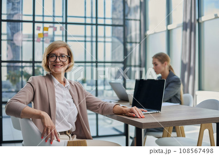 Portrait of young women sitting at his desk in the office Portrait of young women sitting at his desk in the office 108567498