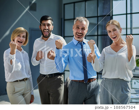 A group of young employees celebrating a victory in front of an office center A group of young employees celebrating a victory in front of an office center 108567504