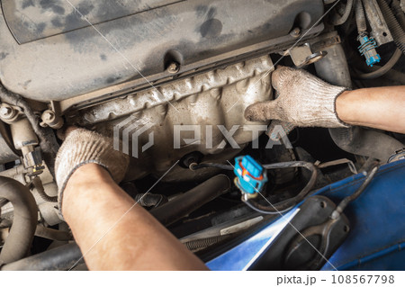 The process of installing collector protection on a car engine, a car service employee at work The process of installing collector protection on a car engine, a car service employee at work 108567798