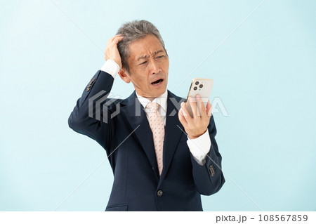 スマートフォンを見て驚くシニア男性 スマートフォンを見て驚くシニア男性 108567859