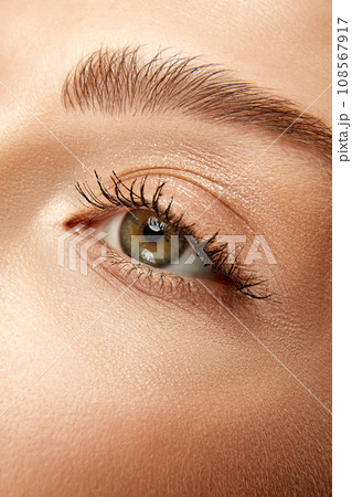 Cropped. Extreme close up view photo of woman with well-kept skin and natural fashion make-up. Eyes, lashes and brows. 108567917