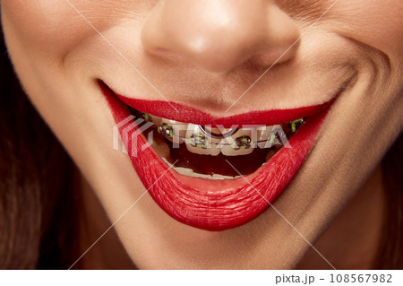 Creepy smile. Close up portrait of beautiful young girl with smiling lips. Lip matte lipstick. Skin care routine. 108567982