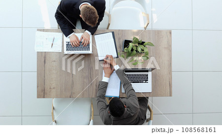 Two successful smiling businessmen are working on a laptop. view from above 108568161