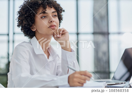 Portrait of Young Successful Caucasian Businesswoman Sitting at Desk Working on Laptop Portrait of Young Successful Caucasian Businesswoman Sitting at Desk Working on Laptop 108568358