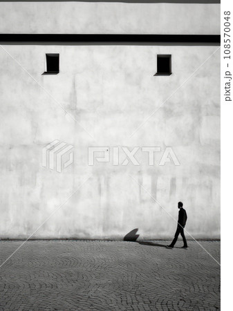 Solitary man walking beside a minimalist building with small windows. Generative AI 108570048