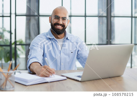 Businessman working on the table with laptop in a new office Businessman working on the table with laptop in a new office 108570215