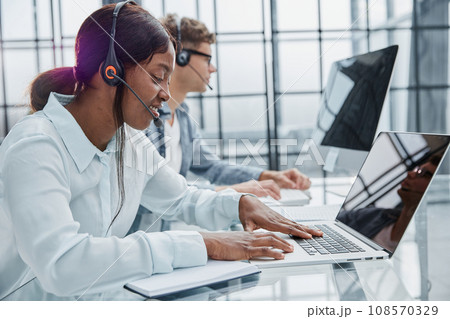 Young friendly operator woman agent with headsets working in a call center Young friendly operator woman agent with headsets working in a call center 108570329