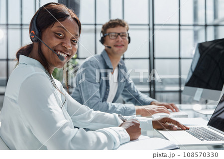 Young friendly operator woman agent with headsets working in a call center 108570330