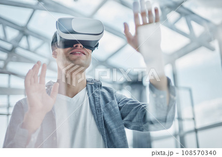 Businessman using vr glasses to view educational material and financial documents Businessman using vr glasses to view educational material and financial documents 108570340