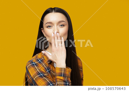 Attractive young woman posing on a yellow background 108570643