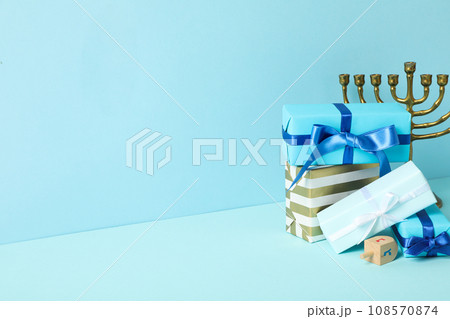 Gift boxes and hanukkiah on blue background, space for text 108570874
