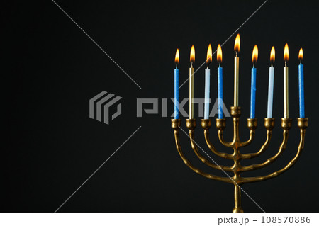 Hanukkiah with nine candles on black background, space for text Hanukkiah with nine candles on black background, space for text 108570886