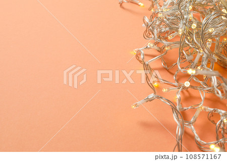 Garland with yellow lights on orange background, space for text Garland with yellow lights on orange background, space for text 108571167