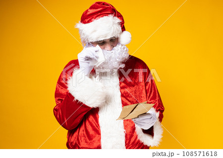 Santa Claus reading a letter with tears in his eyes. 108571618