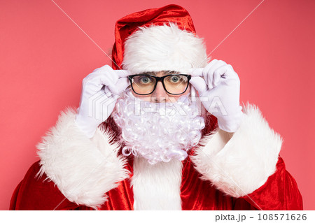 Santa Claus in glasses on a pink background. 108571626