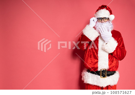 Santa Claus in glasses on a pink background. 108571627