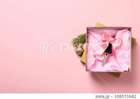 A car key in a box with Christmas decorations. A car key in a box with Christmas decorations. 108571682