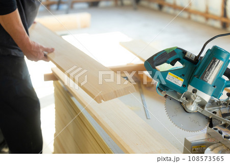 木材カットの電動工具を使う大工 108573565