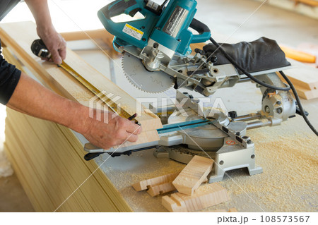 木材カットの電動工具を使う大工 108573567