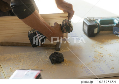 木材を使って大工をする男性 108573654