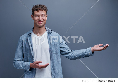 A man on a gray background shows aside A man on a gray background shows aside 108574084