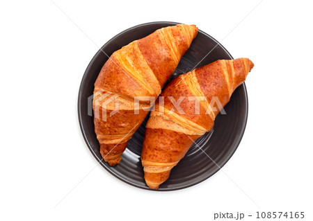 Fresh croissants in a plate on a white background. Top view 108574165