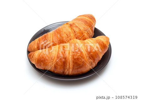 Fresh croissants in a plate on a white background close-up. Fresh croissants in a plate on a white background close-up. 108574319