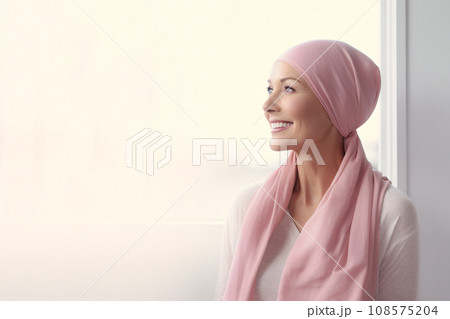 Happy cancer patient. Smiling woman after chemotherapy treatment at hospital oncology department. Breast cancer recovery. Breast cancer survivor. Portrait smiling bald woman with a pink headscarf. 108575204