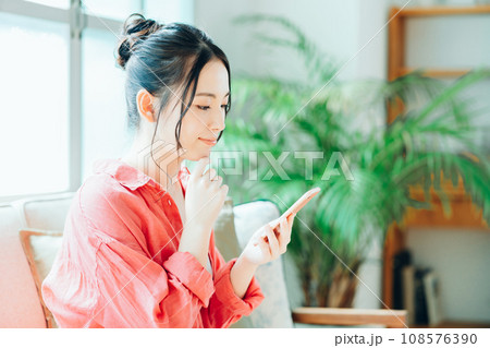 スマートフォンでネットショッピングをする若い女性。 スマートフォンでネットショッピングをする若い女性。 108576390