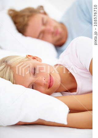 Love, sleep and a couple in a bedroom in the morning to relax in their home together for holiday or vacation. Face, dreaming or eyes closed with a young woman and man in bed in their apartment 108576710