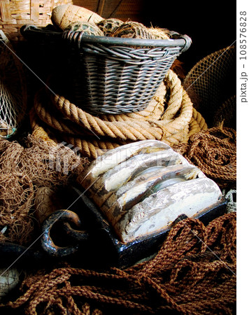 Closeup of fishing basket, lines and rope, net and storage of traditional equipment at port. Tools, fishery and mesh, vintage wood and old metal, retro cordage and antique fishnet in industry Closeup of fishing basket, lines and rope, net and storage of traditional equipment at port. Tools, fishery and mesh, vintage wood and old metal, retro cordage and antique fishnet in industry 108576828