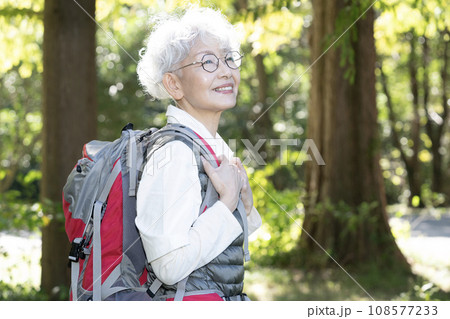 登山バッグを背負って山歩きをする女性 108577233
