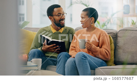 Coffee, reading and happy couple at home on a living room sofa with a man and hot drink. Book, tea and smile with communication and relax conversation together with love and support on a couch 108577687