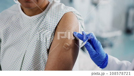 Doctor, hands and bandage on arm, vaccine and healthcare of patient in hospital. Nurse, plaster and injection of person closeup for medicine, virus immunity or help with treatment of injury in clinic Doctor, hands and bandage on arm, vaccine and healthcare of patient in hospital. Nurse, plaster and injection of person closeup for medicine, virus immunity or help with treatment of injury in clinic 108578721