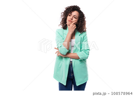 young slender caucasian female model with curly black hair is dressed in a trendy designer jacket in 108578964