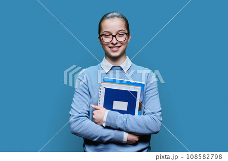 Portrait of teenager girl high school student on blue background 108582798