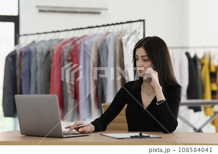 Woman talks with client checking information on laptop 108584041