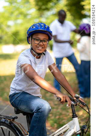 Kids spending time with dad and learning to ride a bike 108584214