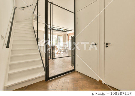 the inside of a house with wood flooring and white walls, stairs leading up to an open door that leads to another room 108587117